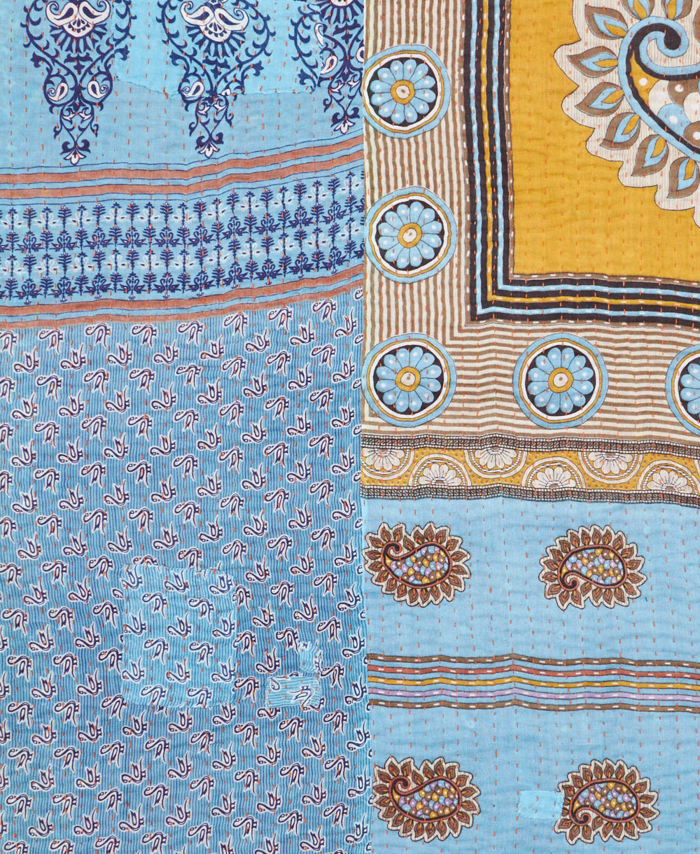 kantha quilt throw with a tag featuring the hand-stitched signature of the maker