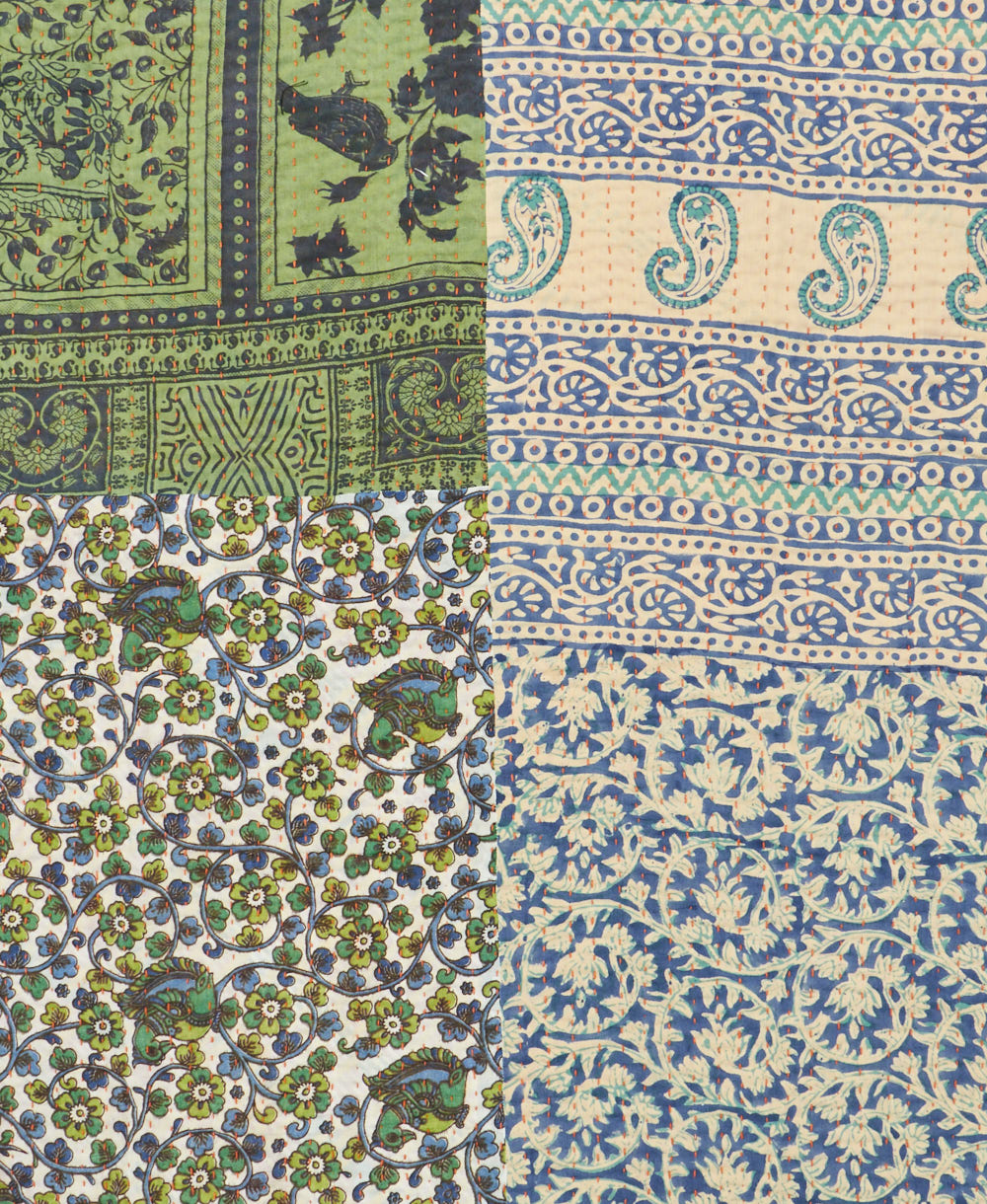 kantha quilt throw with a tag featuring the hand-stitched signature of the maker