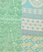 kantha quilt throw with a tag featuring the hand-stitched signature of the maker