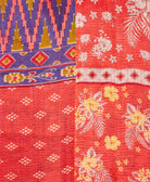 kantha quilt throw with a tag featuring the hand-stitched signature of the maker