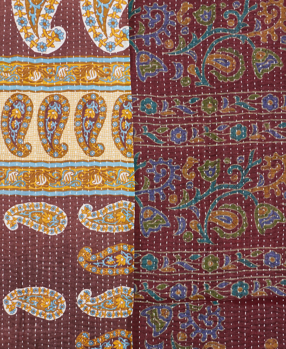 kantha quilt throw with a tag featuring the hand-stitched signature of the maker