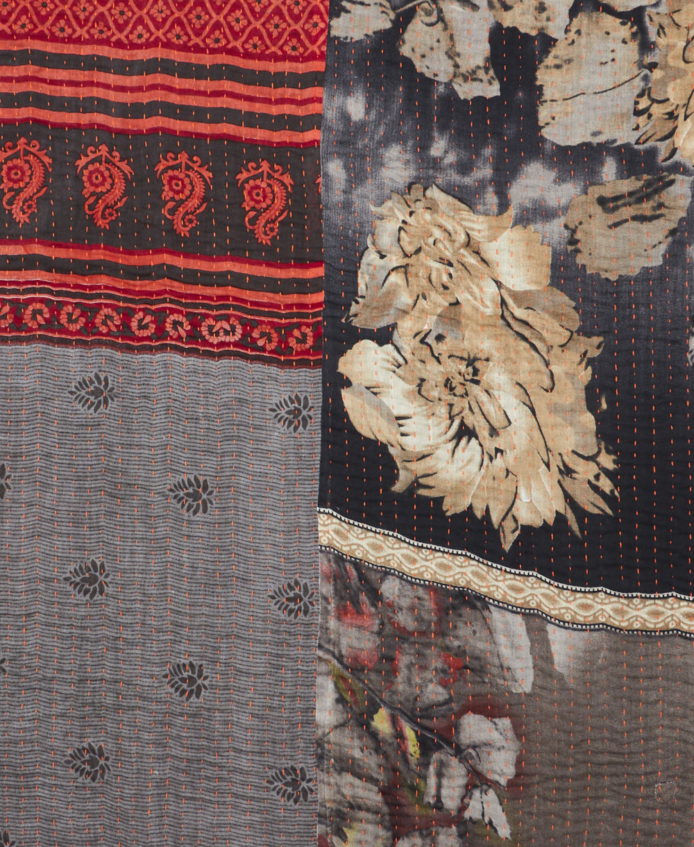 kantha quilt throw with a tag featuring the hand-stitched signature of the maker