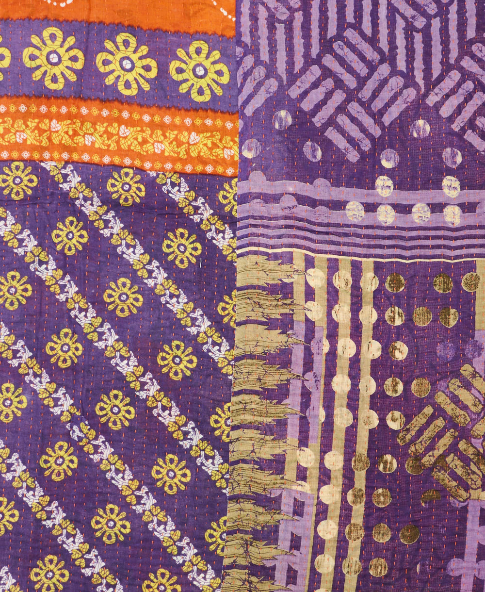 kantha quilt throw with a tag featuring the hand-stitched signature of the maker