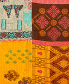 kantha quilt throw with a tag featuring the hand-stitched signature of the maker