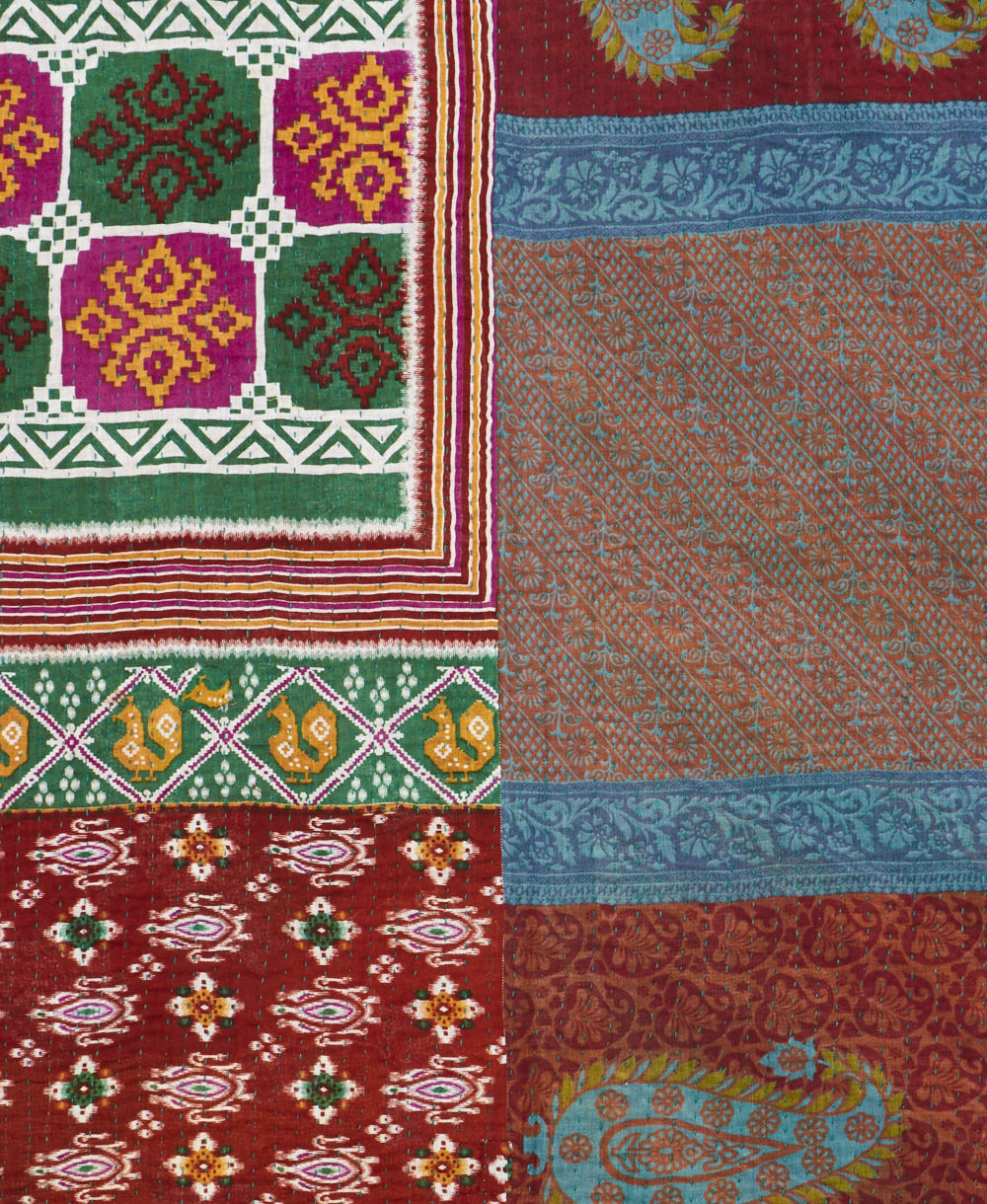 kantha quilt throw with a tag featuring the hand-stitched signature of the maker