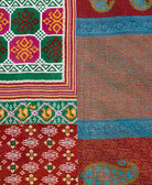 kantha quilt throw with a tag featuring the hand-stitched signature of the maker