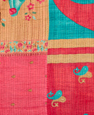 kantha quilt throw with a tag featuring the hand-stitched signature of the maker