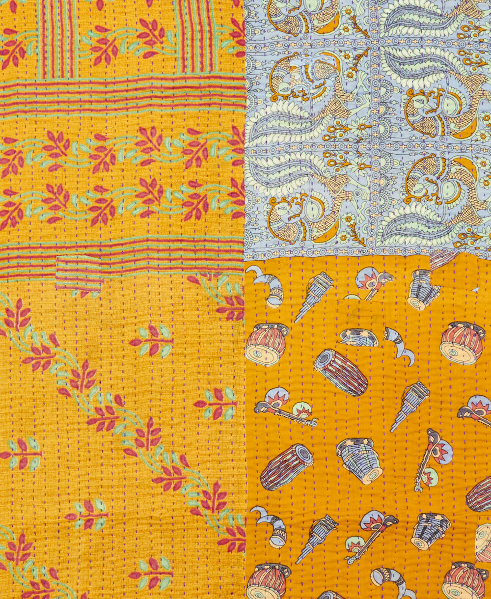 kantha quilt throw with a tag featuring the hand-stitched signature of the maker