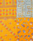 kantha quilt throw with a tag featuring the hand-stitched signature of the maker