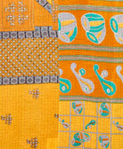 kantha quilt throw with a tag featuring the hand-stitched signature of the maker