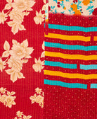 kantha quilt throw with a tag featuring the hand-stitched signature of the maker