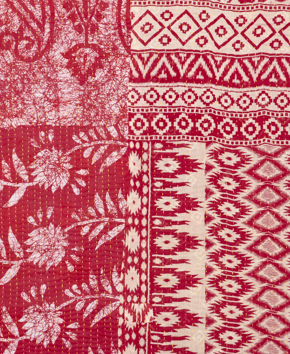 kantha quilt throw with a tag featuring the hand-stitched signature of the maker