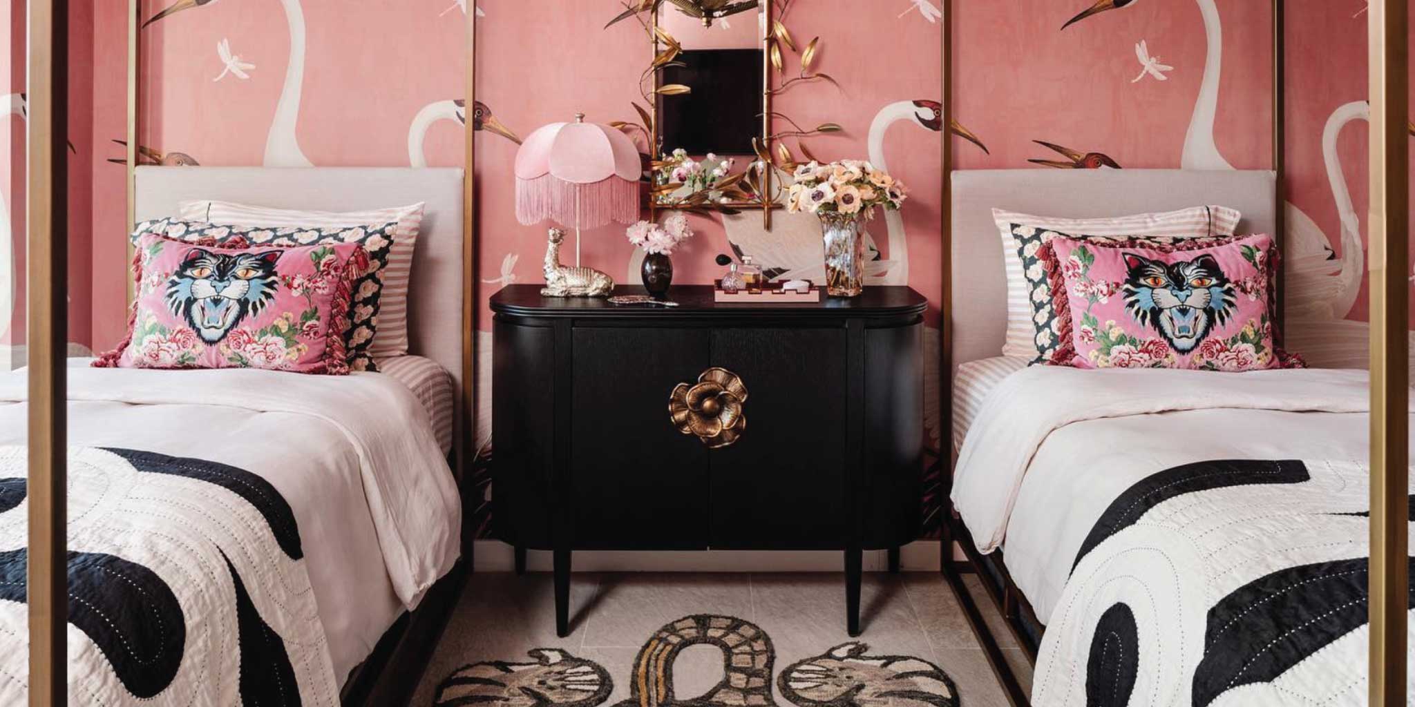 two twin beds in hotel room with white and pink crane wallpaper and matching black and white quilts on bed