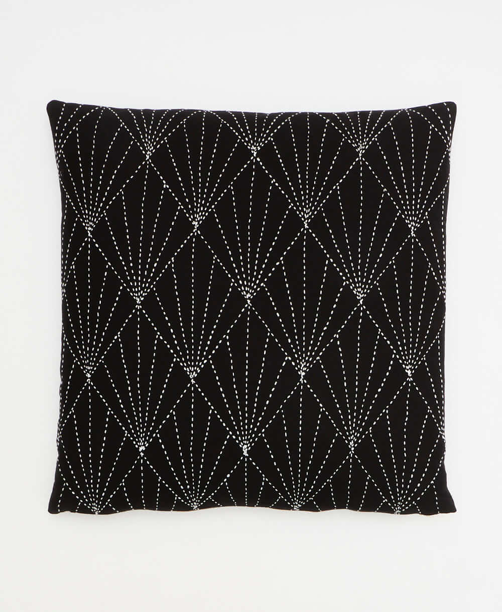 black throw pillow with graphic white hand-embroidery creating an art-deco fan pattern