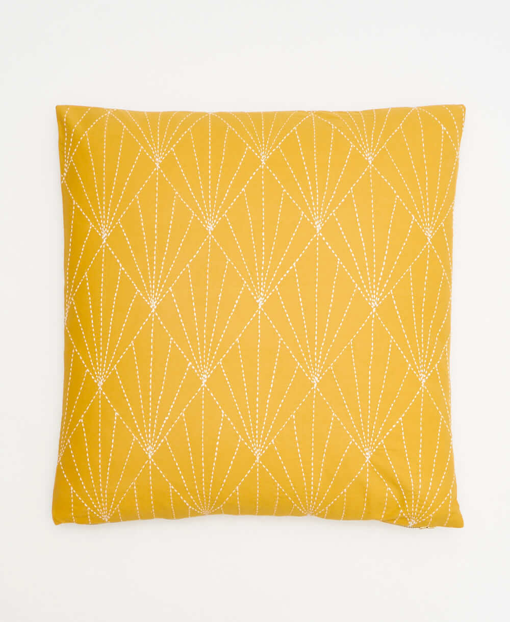 mustard yellow throw pillow with white kantha embroidery in a fan pattern