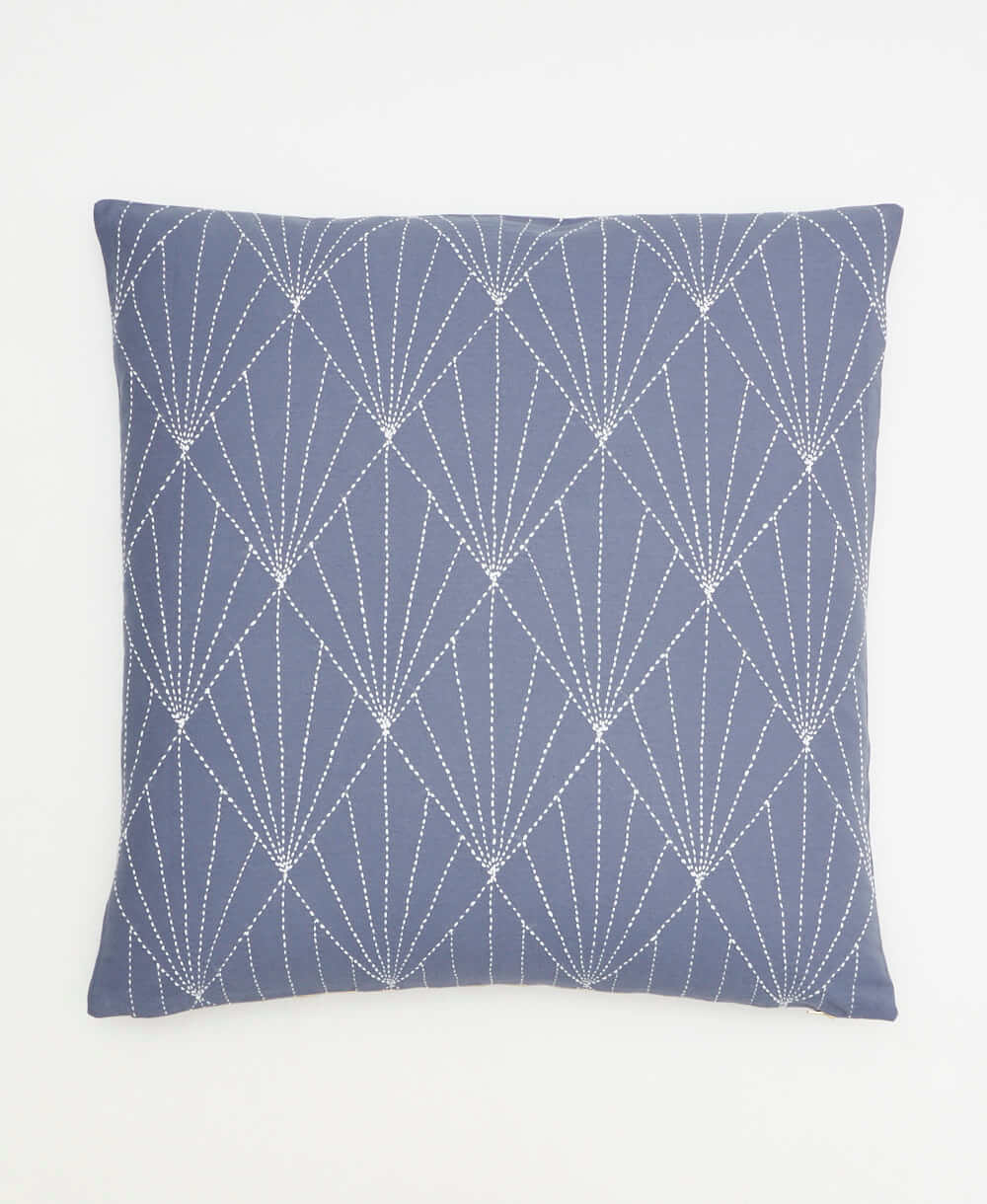 slate blue throw pillow with bold white embroidery creating a repeating fan pattern