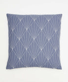 slate blue throw pillow with bold white embroidery creating a repeating fan pattern