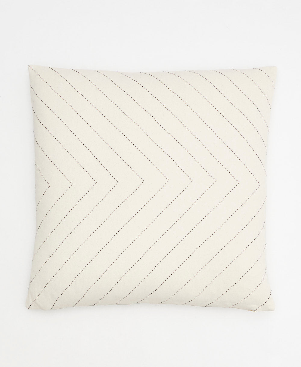 ivory throw pillow with black embroidery forming a geometric arrow pattern handmade with organic cotton