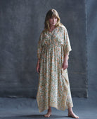 woman wearing orange, pink & green floral organic cotton kaftan with adjustable empire waist