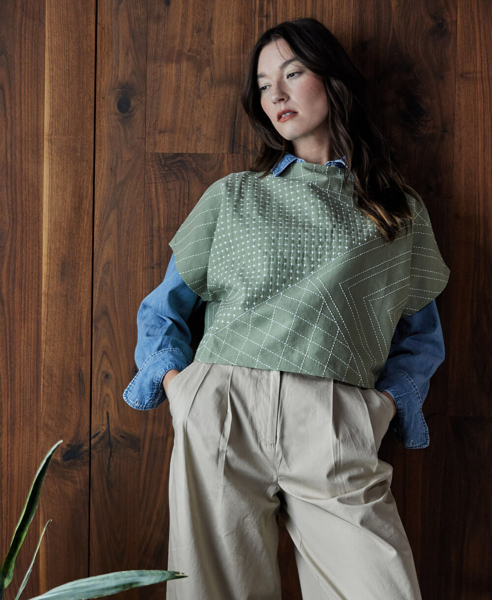 woman wearing embroidered green crop top over denim button-down shirt with wide leg khaki trousers