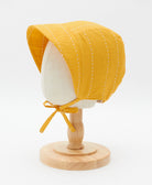 mustard yellow brimmed bonnet with chin ties and beautiful white embroidery handmade in India