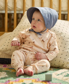 baby girl wearing slate blue brimmed baby bonnet with white embroidery made from organic cotton