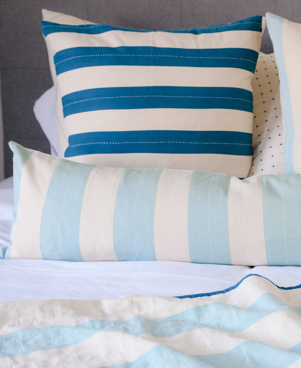 light blue vertically striped extra long lumbar pillow paired with horizontally stripe cobalt pillow