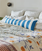 cobalt blue stripe long bed pillow on all white bed with neutral king kantha quilt