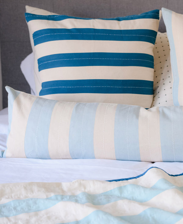 long skinny lumbar pillow with kitschy oversized stripe design in sky blue 