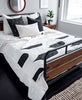 modern minimalist bedroom with black and white canopy quilt draped at the end of bed