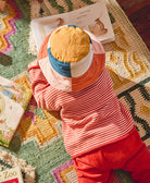 sustainable cotton baby bucket hat in modern colorblock checkered pattern on baby reading a book