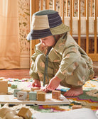 toddler wearing canvas baby bucket hat in blue and green checkered design handmade by mothers in India