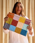 woman holding quilted checkered laptop sleeve in front of her 