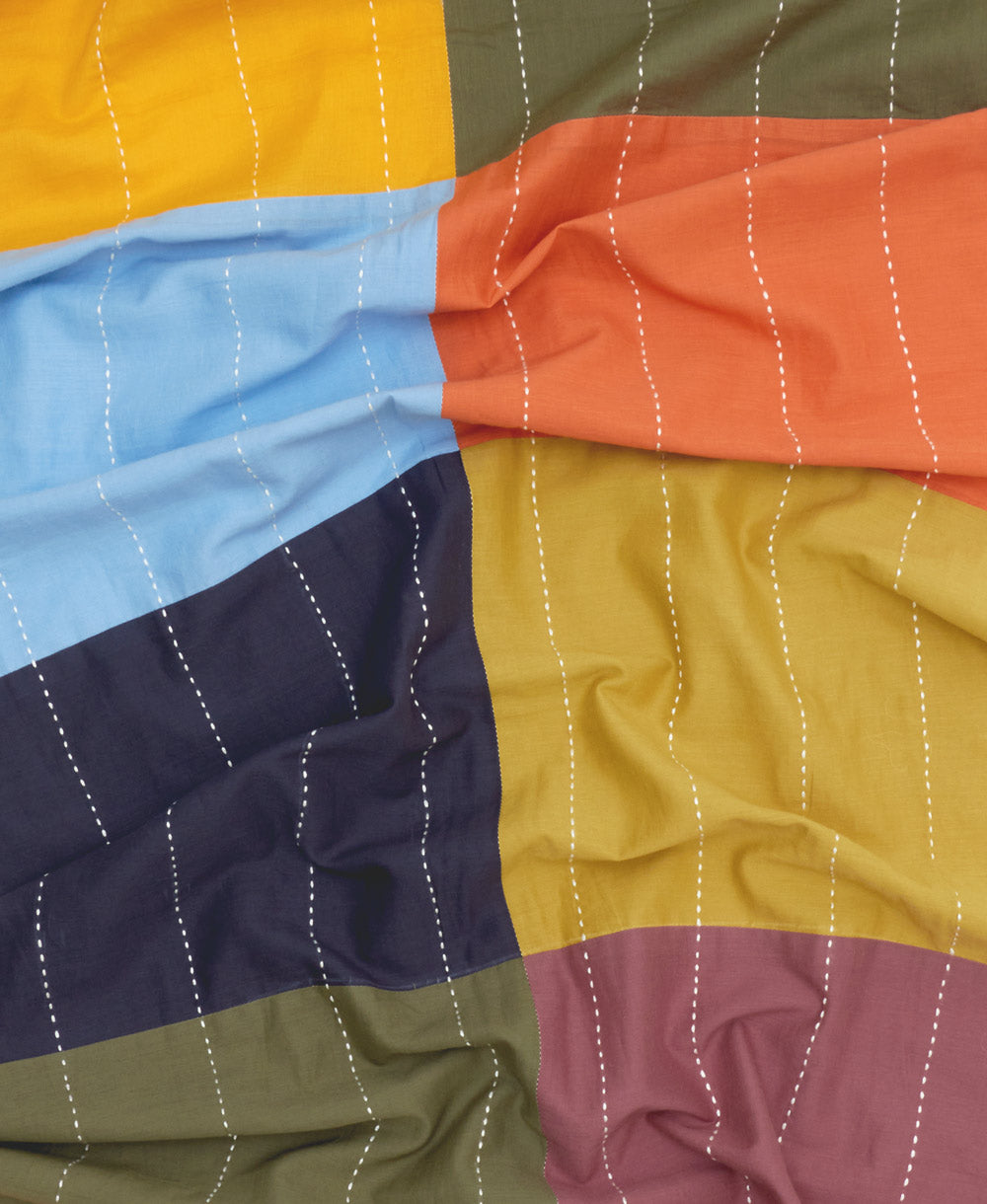 Colorful organic cotton scarf with geometric pattern on a plain background