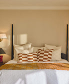 Bed with decorative pillows and a lamp on a nightstand in a bedroom setting