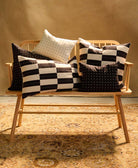 black and white pillows on a wooden bench