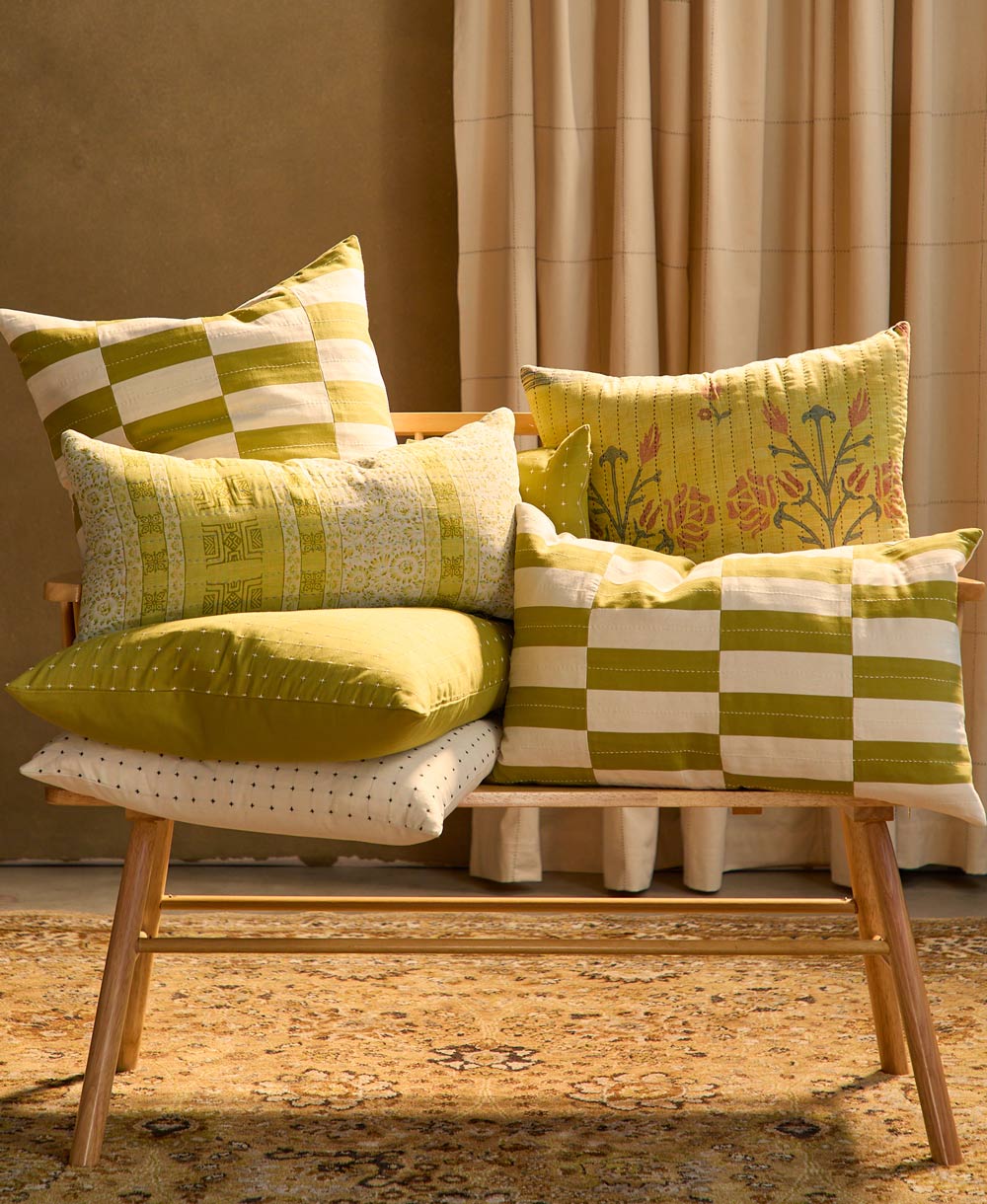 Chair with colorful checkered pillows against a neutral wall