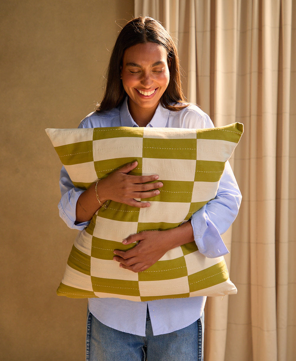 woman holding moss checkered toss pillow
