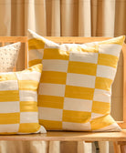 mustard checkered toss pillow on bench