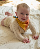 baby girl wearing yellow & pink bandana baby bib made from 100% certified organic cotton