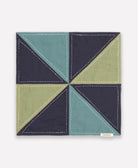 organic cotton bandana bib in modern patchwork design in cool colors of navy, spruce and sage green