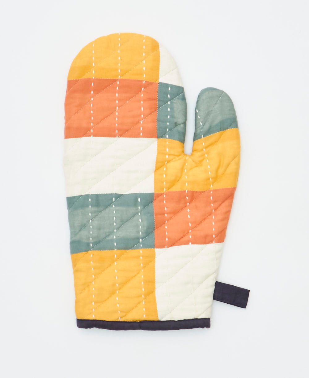 Patchwork-style oven mitt with geometric pattern on a white background