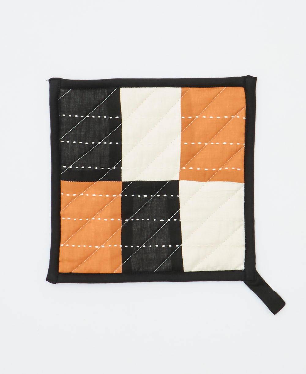 Quilted pot holder with a checkered pattern on a white background