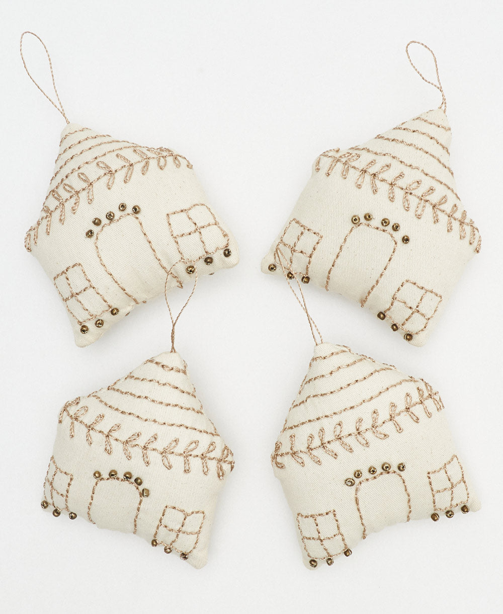 group of white and gold house-shaped fabric ornaments handmade from organic cotton in India by women artisans