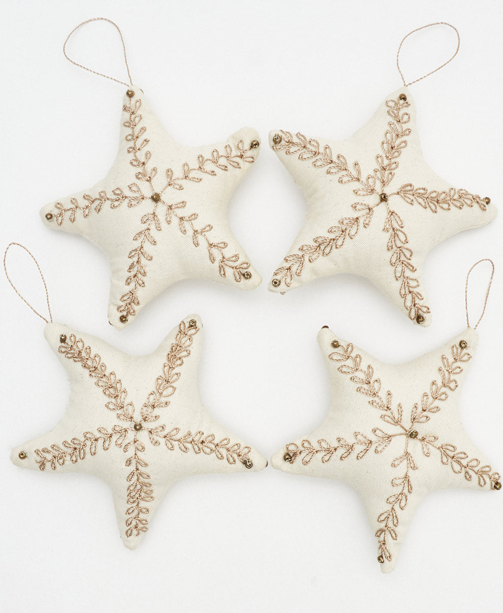 handmade fabric ornaments in star shapes with gold embroidery and gold beading