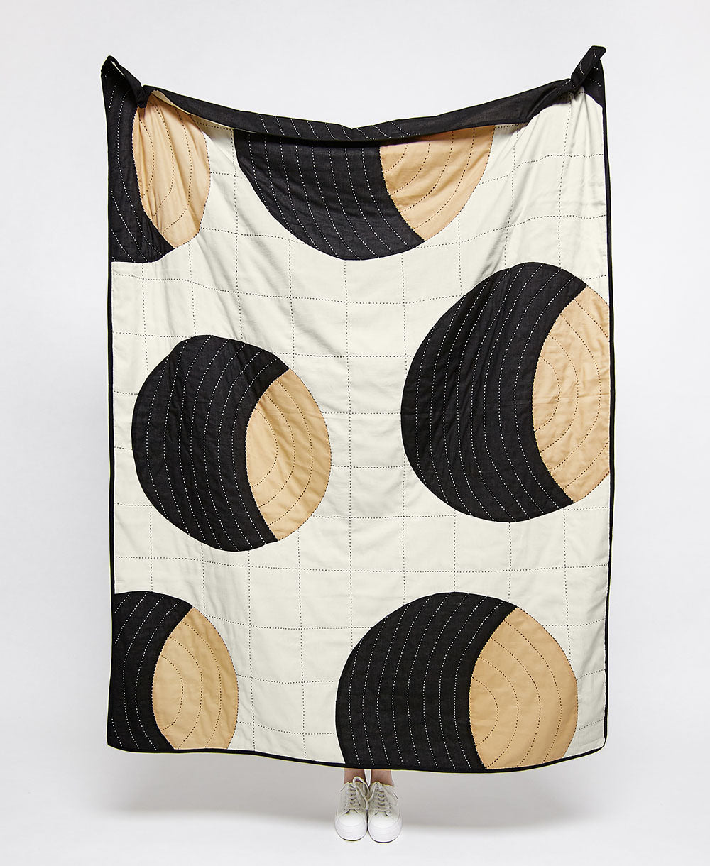 crescent lattice patchwork quilt with bold graphic circular design in tan and black