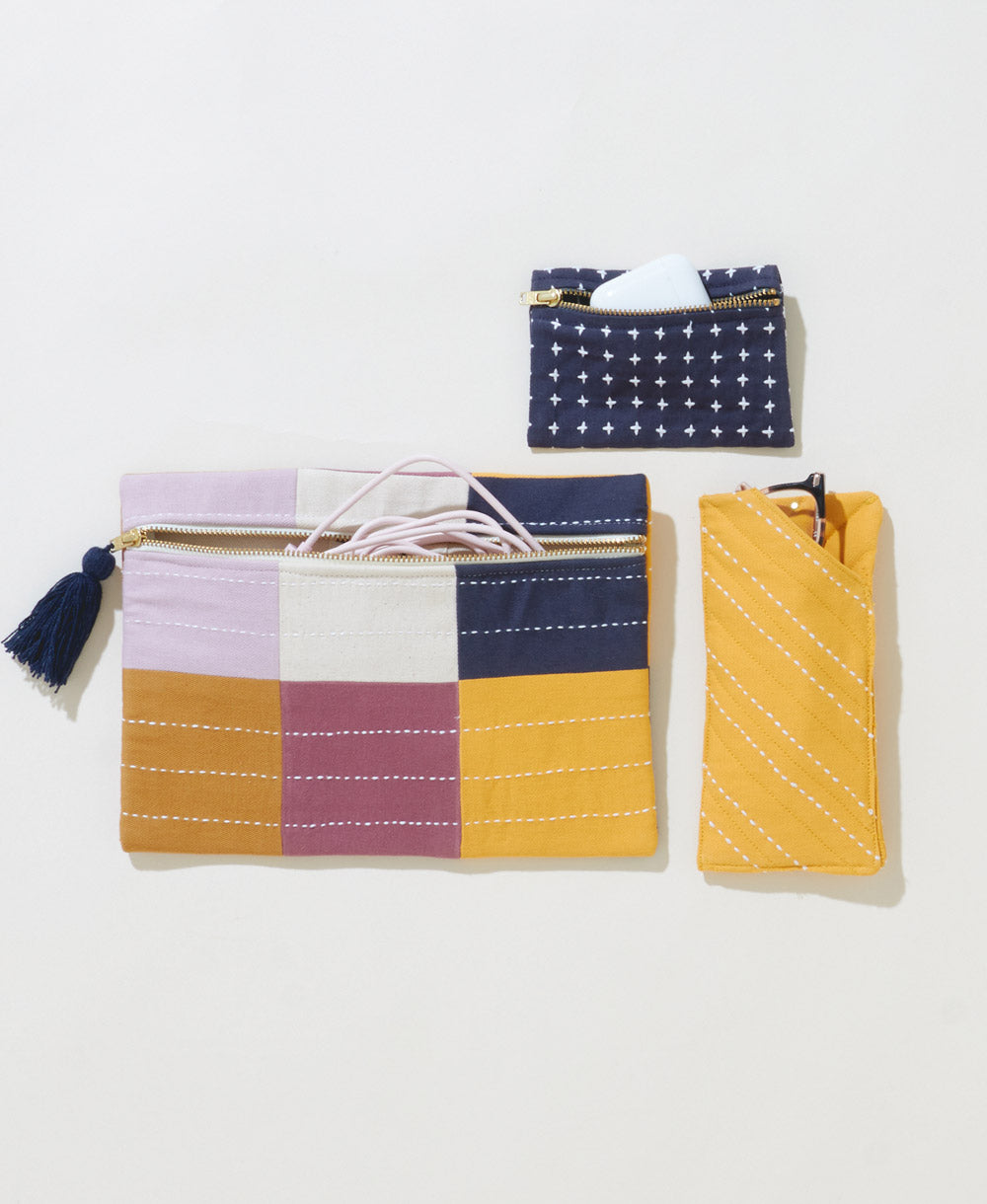 navy cross-stitch coin purse holding air pods with glasses case and checkered small pouch