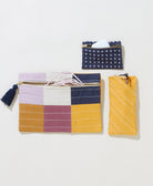 navy cross-stitch coin purse holding air pods with glasses case and checkered small pouch