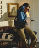 Woman holding a black handbag in a room with a horse painting on the wall