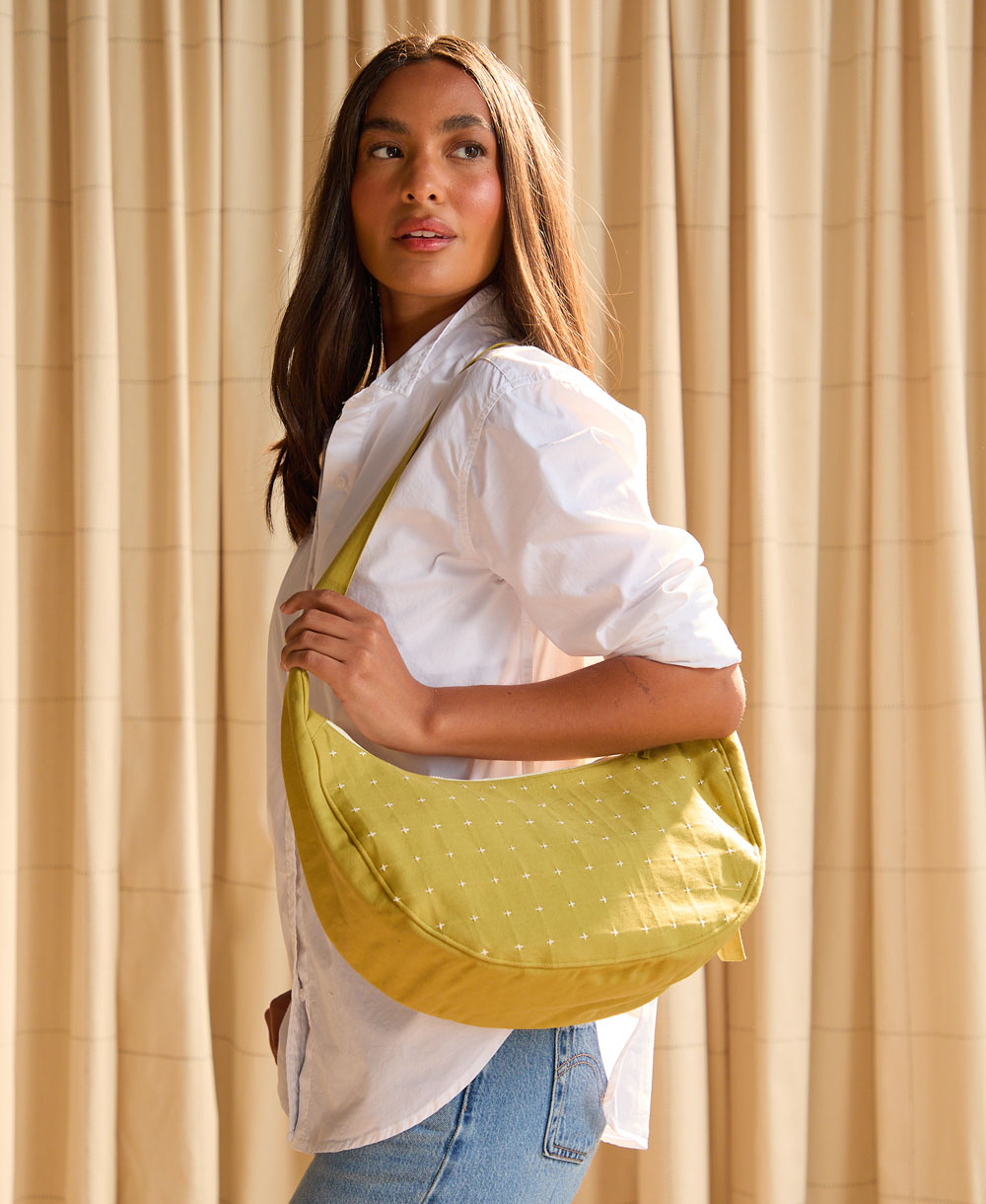 woman holding moss crescent bag over shoulder